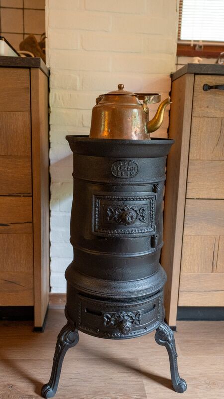 Oude potkachel met koperen ketel